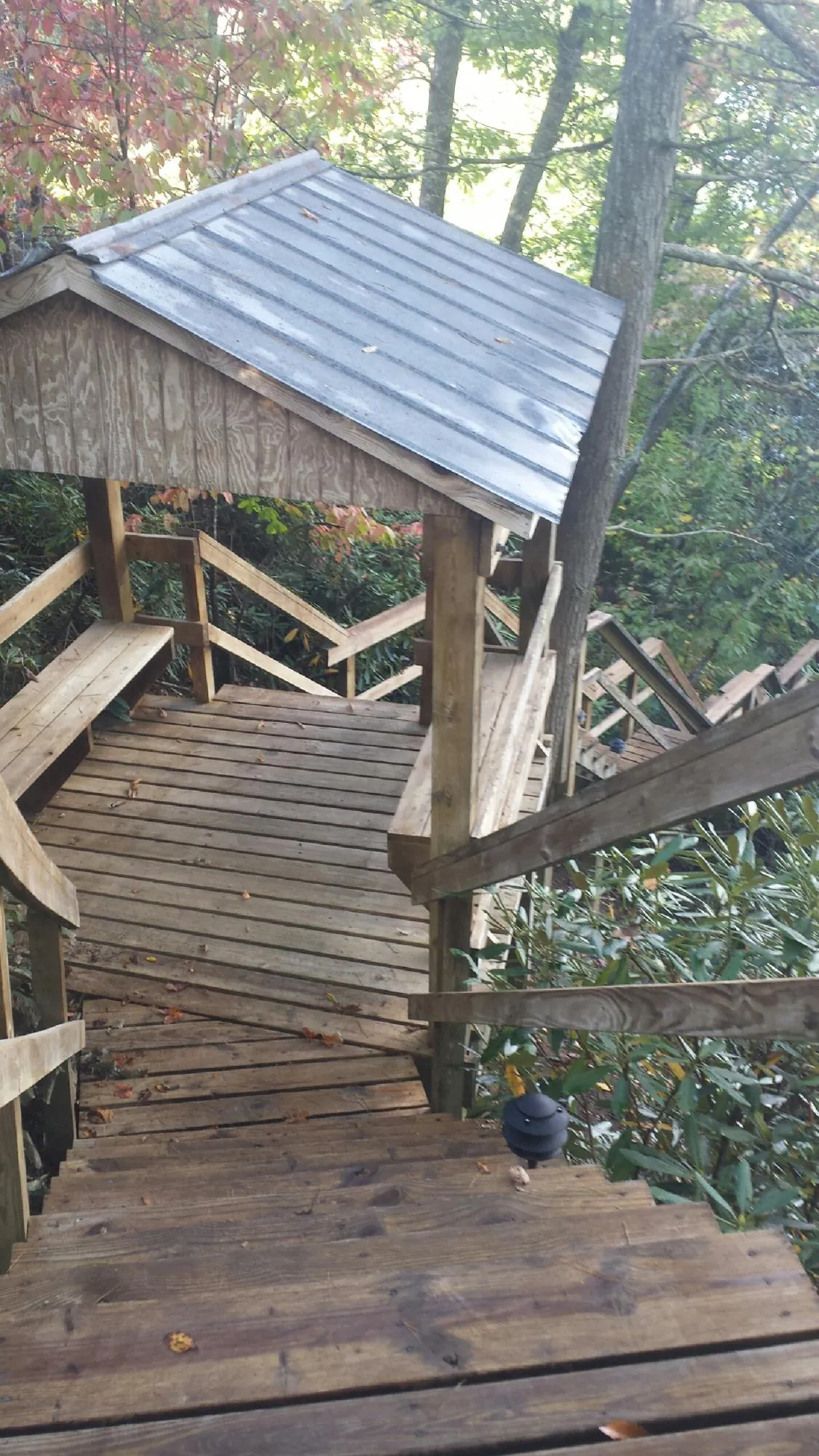 Metal roofed shelter over wooden steps on a wooded walkway — Skylight Repair & Installation work by our crew in O Brien